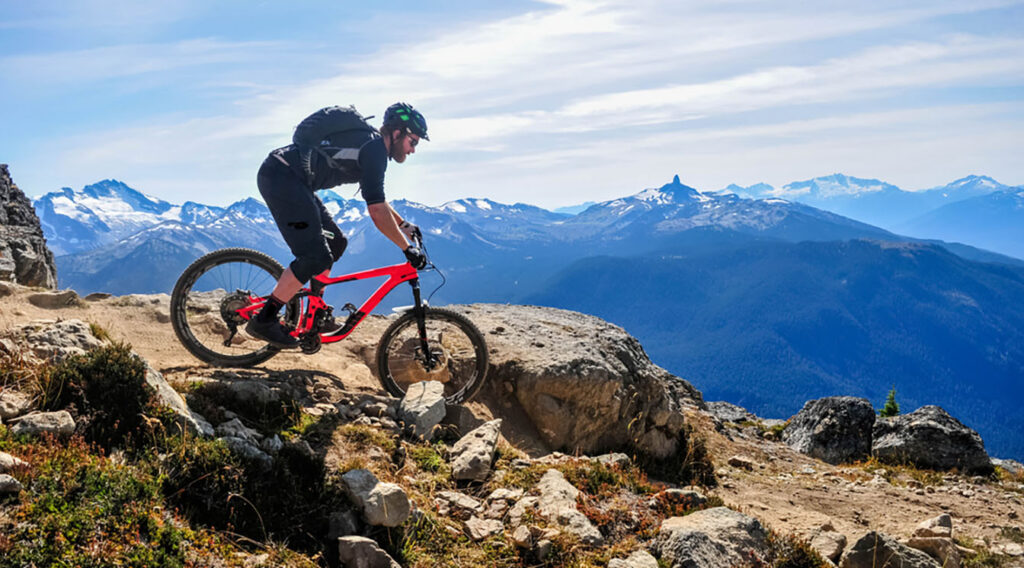 Mountain bike rider going down steep sloap